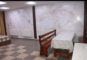 a room with a table and a bench and a marble wall at House in downtown in Bălţi