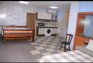 a room with a bed and a kitchen with a bench at House in downtown in Bălţi