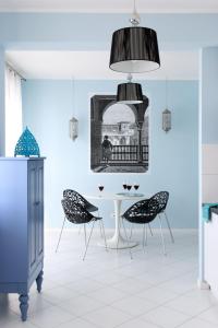 a dining room with a white table and black chairs at Sleep Dream in Warsaw