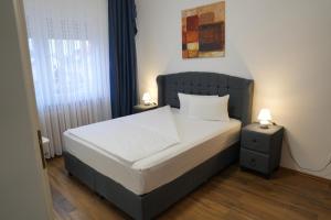 a bedroom with a bed with a black headboard at Bovino Hotel in Raunheim