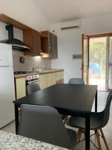 uma cozinha com uma mesa preta e cadeiras em Villa panoramica con giardino - Casa Valù em Cassano delle Murge