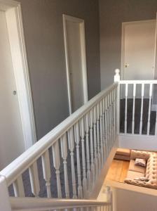 a white staircase with a white railing in a house at 2 bedroom apartment, great location for tourists in Liverpool
