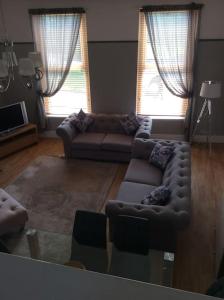 a living room with two couches and two windows at 2 bedroom apartment, great location for tourists in Liverpool