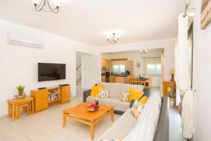 a living room with a couch and a table at Villa Maya - 4bed with Private Heated Pool in Paralimni