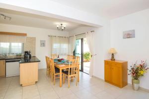 a kitchen and dining room with a table and chairs at Villa Maya - 4bed with Private Heated Pool in Paralimni