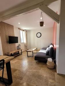 a living room with a couch and a table at Le Quai in Saint-Vincent-de-Cosse