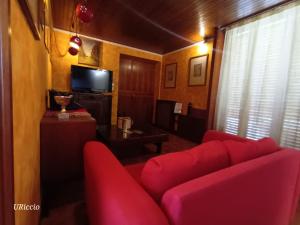 a living room with a red couch and a television at Casa Riccio in Palermo