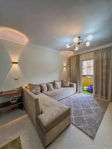 開羅的住宿－Joe Excellence Residence，客厅配有沙发和桌子