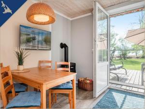 a dining room with a wooden table and chairs at Ferienwohnung mit Kamin am Achterwasser in Lütow in Lütow +11 photos