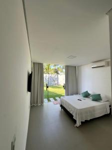 a bedroom with a bed and a large window at Cantinho do sossego in Porto Seguro