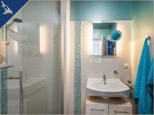 a white bathroom with a sink and a shower at Ferienwohnung mit Kamin am Achterwasser in Lütow in Lütow