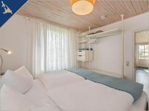 a bedroom with a large white bed and a window at Ferienwohnung mit Kamin am Achterwasser in Lütow in Lütow