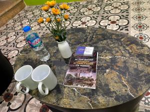 a table with a book and a bottle of water and flowers at Hanoi Old Quarter Inn in Hanoi