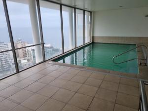 una piscina en un edificio con ventanas en Delpino Propiedades Palmas del Mar, en Viña del Mar