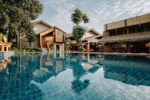a swimming pool in front of a building at U OLIVE Hotel in Ban Nua