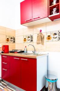 una cocina con armarios rojos y fregadero en Cazare urbana, en Brasov