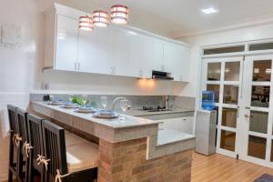 a kitchen with white cabinets and a stone counter top at Strata Homestay- Luxurious 2- Storey Townhouse in Baguio