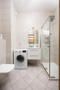 a bathroom with a washing machine and a washer at 11th Floor Praga View Apartment in Warsaw