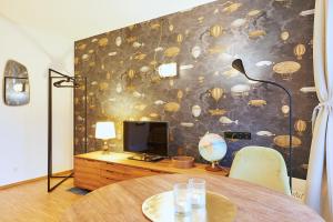 a room with a table and a tv and a wall at Explorer Apartment Düsseldorf in Düsseldorf