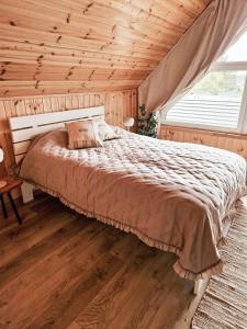 a bedroom with a bed with a wooden ceiling at REST HOUSE WDZYDZE DOMKI NAD JEZIOREM in Wdzydze Kiszewskie