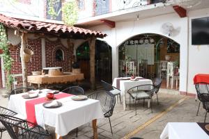 an outdoor patio with white tables and chairs at HOTEL PALACIO CHATINO in Santos Reyes Nopala