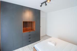 a bedroom with a bed and a wall with cabinets at Como Life Inn in Bragadiru