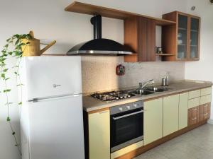 uma cozinha com um frigorífico branco e um lavatório em Villa panoramica con giardino - Casa Valù em Cassano delle Murge