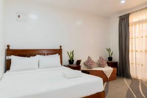 a hotel room with a bed and a chair at Strata Homestay- Luxurious 2- Storey Townhouse in Baguio