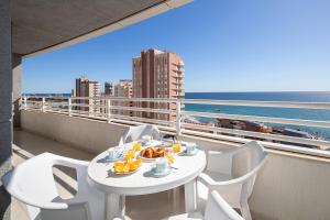 a table and chairs on a balcony with a view of the ocean at Homeincalpe Apolo XIV in Calpe