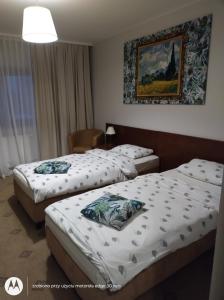Cette chambre comprend 2 lits et une photo murale. dans l'établissement Campoverde, à Łódź