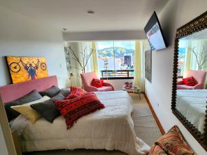 um quarto com uma cama com almofadas e um espelho em Apartamento de lujo en zona exclusiva de Cusco em Cusco