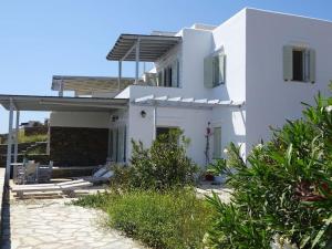 a white house with a patio in front of it at Sun Blooming Villa in Tinos island in Agios Romanos