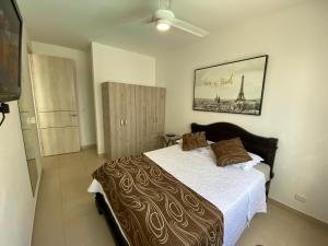 1 dormitorio con 1 cama y una pintura en la pared en Aqualina Orange Apartamento Piso 3 Vista a Piscina 3 Habitaciones, en Girardot