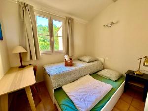 een slaapkamer met 2 aparte bedden en een raam bij Les Restanques 3120 vue mer 3 chambres in Grimaud