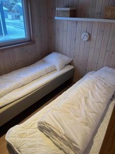 two twin beds in a room with a window at Storebælt camping in Korsør