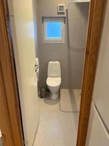 een kleine badkamer met een toilet en een raam bij Storebælt camping in Korsør