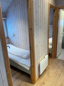 a small room with a bed and a mirror at Storebælt camping in Korsør