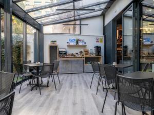 Un restaurante con mesas y sillas y un mostrador. en Ibis Budget Madrid Centro Lavapies, en Madrid