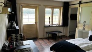 1 dormitorio con cama, ventana y puerta en B&B De Handwijzer Hengelo en Hengelo