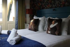 a hotel room with two beds with pillows with at Hotel West Inn in Hippolytushoef