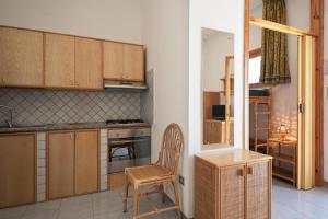 una cocina con armarios de madera y una silla en una habitación en Trilo 6, en Lido Marini