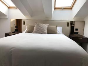 1 cama blanca grande en una habitación con ventanas en Quatrecantons Camprodon, en Camprodon