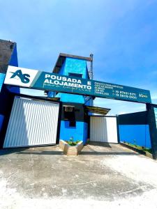 a blue and white building with a sign on it at Pousada Alojamento AS in Viracopos