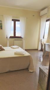 una camera da letto con un letto grande con tende bianche di Casa il Frutteto Pompei a Pompei