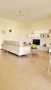 un soggiorno con un divano bianco e un tavolo di Casa il Frutteto Pompei a Pompei