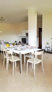 un tavolo da pranzo bianco con sedie in camera di Casa il Frutteto Pompei a Pompei