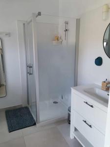 a white bathroom with a shower and a sink at Charmante maisonnée à la campagne in La Garnache