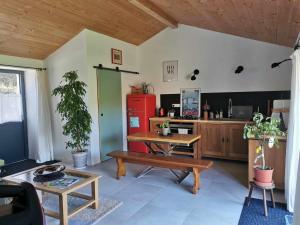 a living room with a table and a red refrigerator at Charmante maisonnée à la campagne in La Garnache