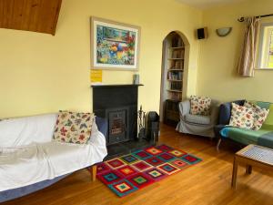 a living room with a couch and a fireplace at Dunmanus Cottage West Cork in Durrus