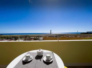 una mesa con dos sombreros y vistas a la playa en Faro y Playa, en Morro del Jable